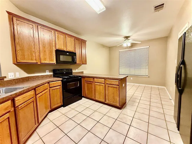 a kitchen with stainless steel appliances granite countertop a stove top oven a sink a counter top space and cabinets