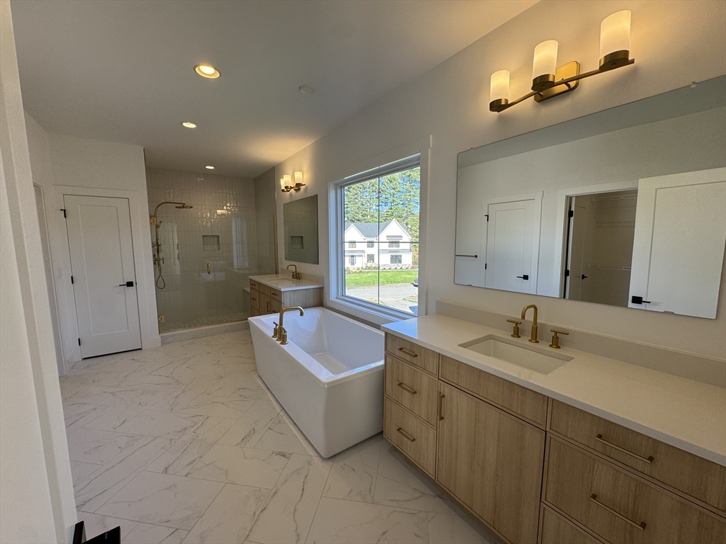 12 Old County Road, Unit 20 Hudson, MA 01749 - Photo 26 of 30 a spacious bathroom with a bathtub sink and mirror