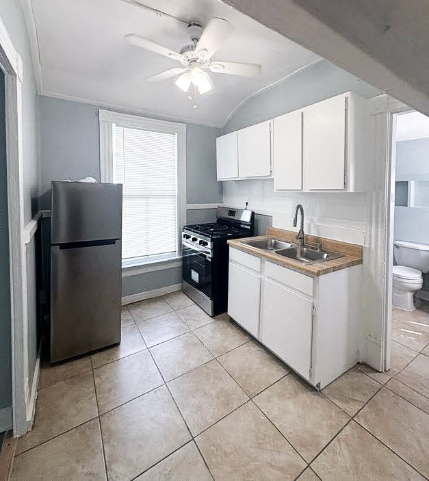 1810 24th Street Rear, Unit 3 Galveston, TX 77550 - Photo 6 of 8 a kitchen with a refrigerator a sink and cabinets