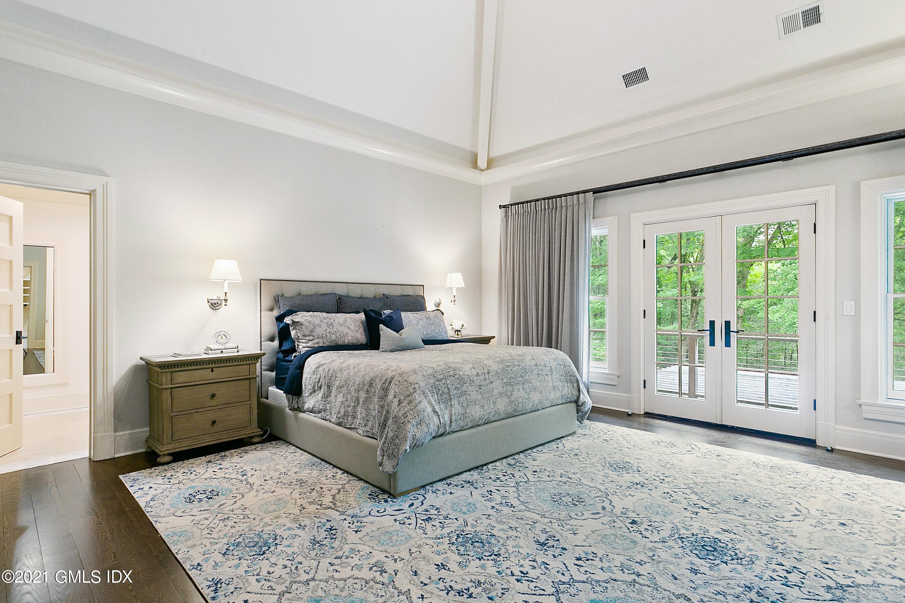 125 Cat Rock Road Cos Cob, CT 06807 - Photo 16 of 45 a bedroom with a large bed and wooden floor