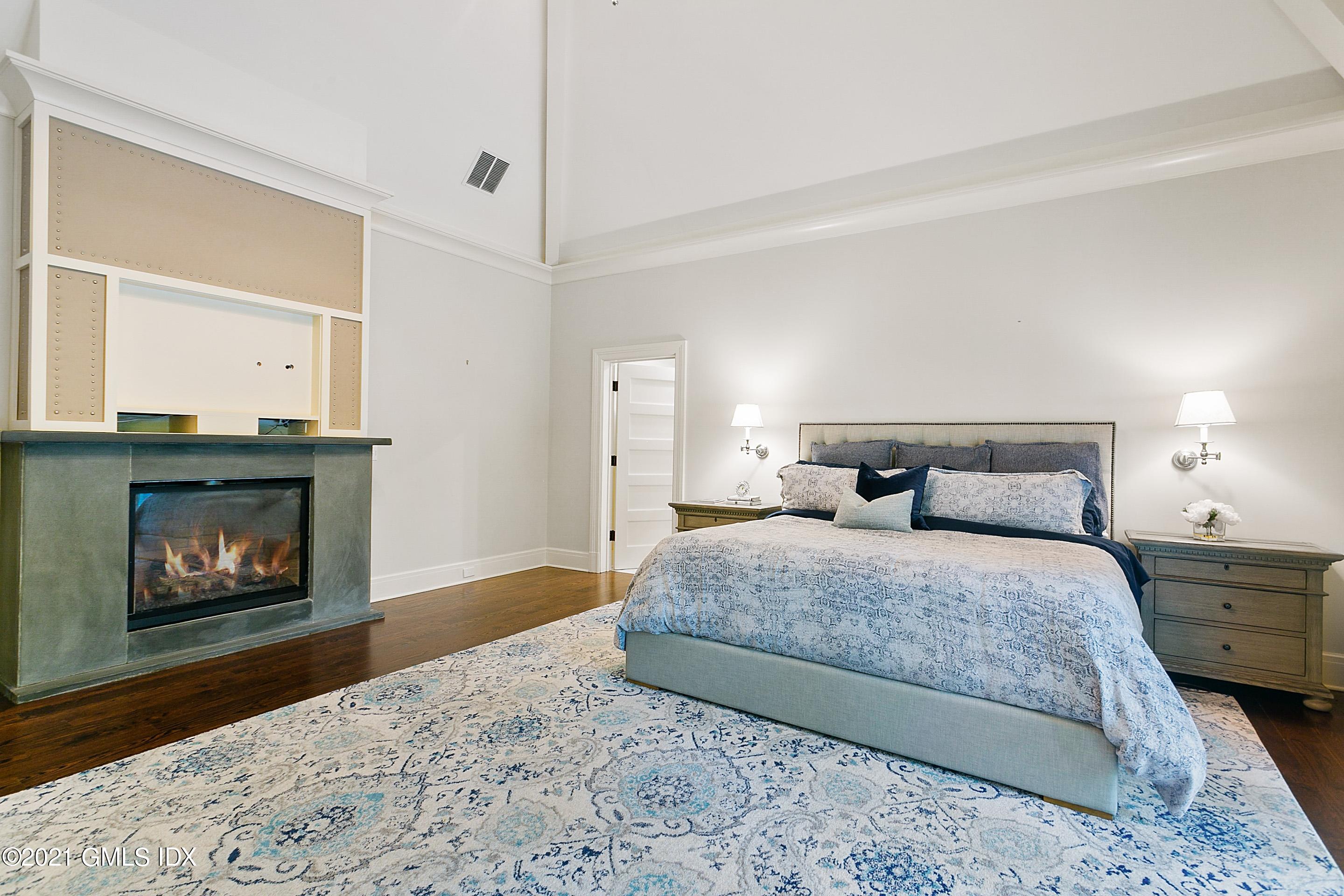 125 Cat Rock Road Cos Cob, CT 06807 - Photo 17 of 45 a bedroom with a bed and a fireplace