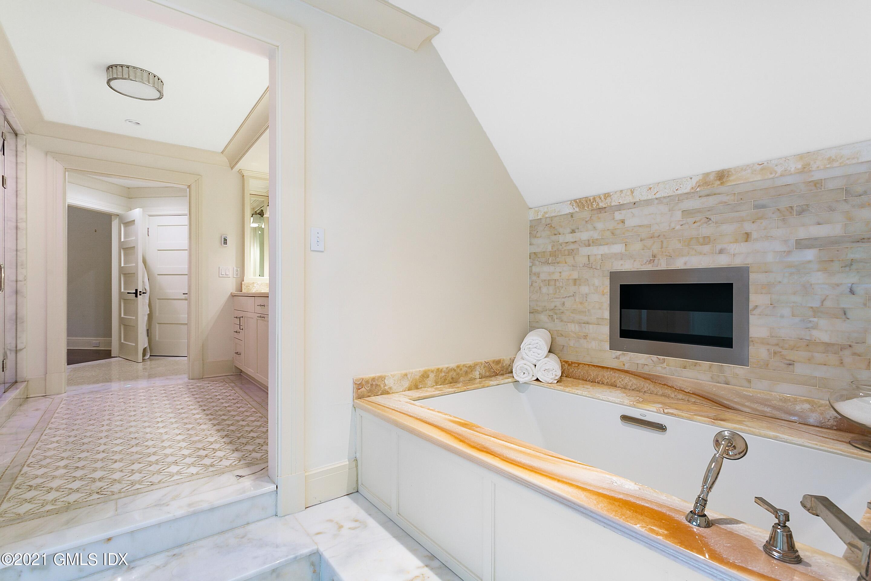 125 Cat Rock Road Cos Cob, CT 06807 - Photo 19 of 45 a bathroom with a tub sink and mirror