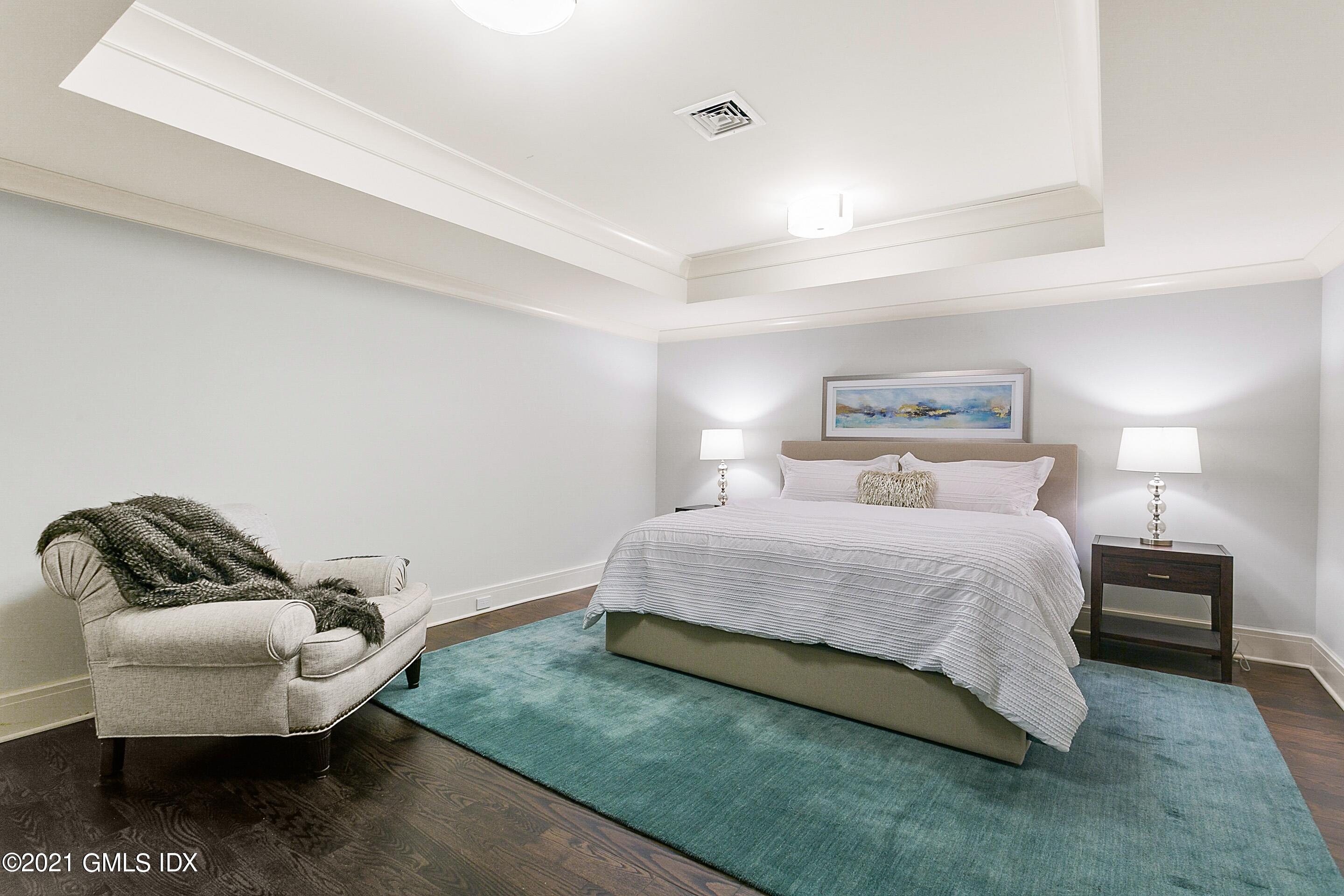 125 Cat Rock Road Cos Cob, CT 06807 - Photo 32 of 45 a bedroom with a bed and chair