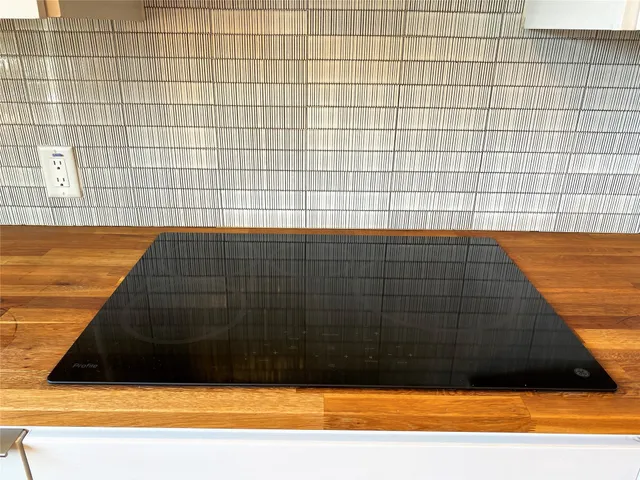 a kitchen with granite countertop stainless steel appliances sink stove and cabinets