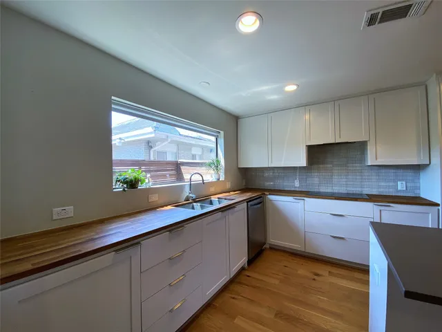 a view of a kitchen with a refrigerator and wooden floor