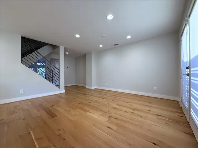 a view of an empty room with wooden floor and closet