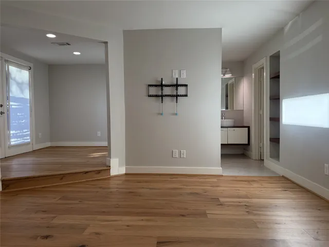 a view of a big room with wooden floor and windows