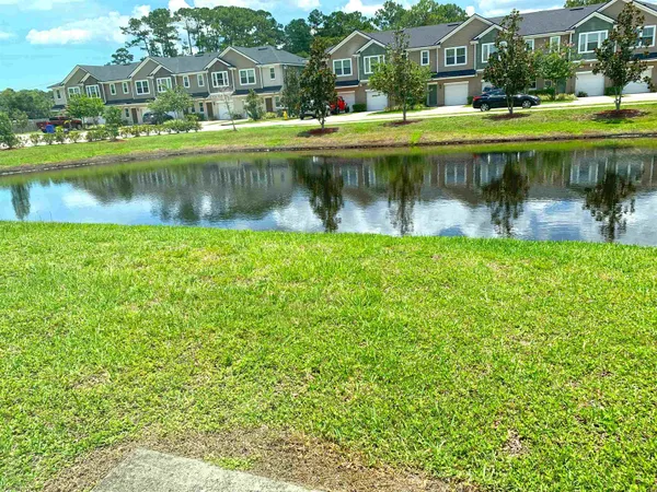 a view of a house with a yard and a pond