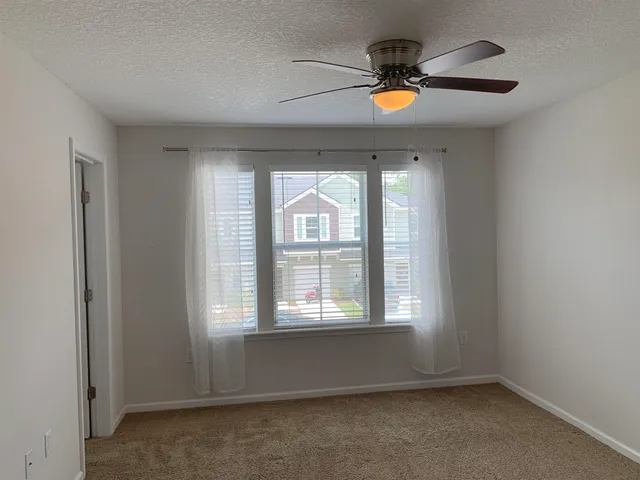 an empty room with a window and a ceiling fan