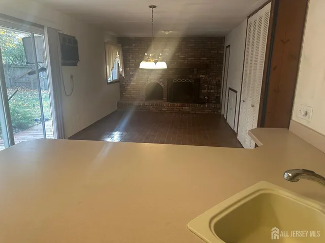 a view of empty room with wooden floor and fireplace