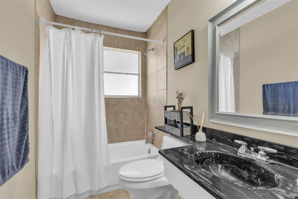 2311 Arcady Lane Lancaster, TX 75134 - Photo 19 of 22 a bathroom with a granite countertop sink toilet a mirror and shower