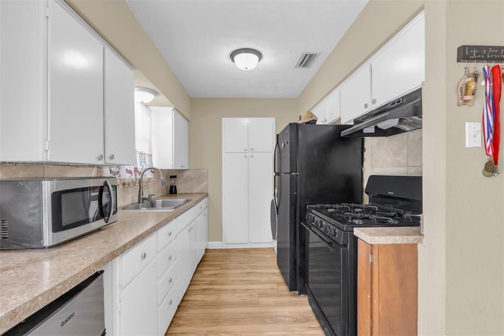 2311 Arcady Lane Lancaster, TX 75134 - Photo 8 of 22 a kitchen with stainless steel appliances a refrigerator a sink and a stove