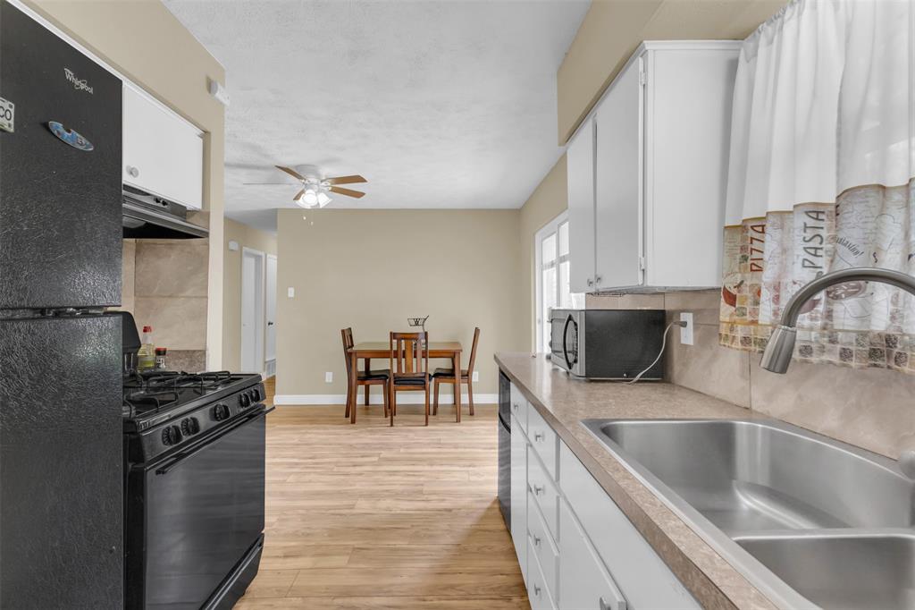 2311 Arcady Lane Lancaster, TX 75134 - Photo 9 of 22 a kitchen with granite countertop a stove a sink and a refrigerator
