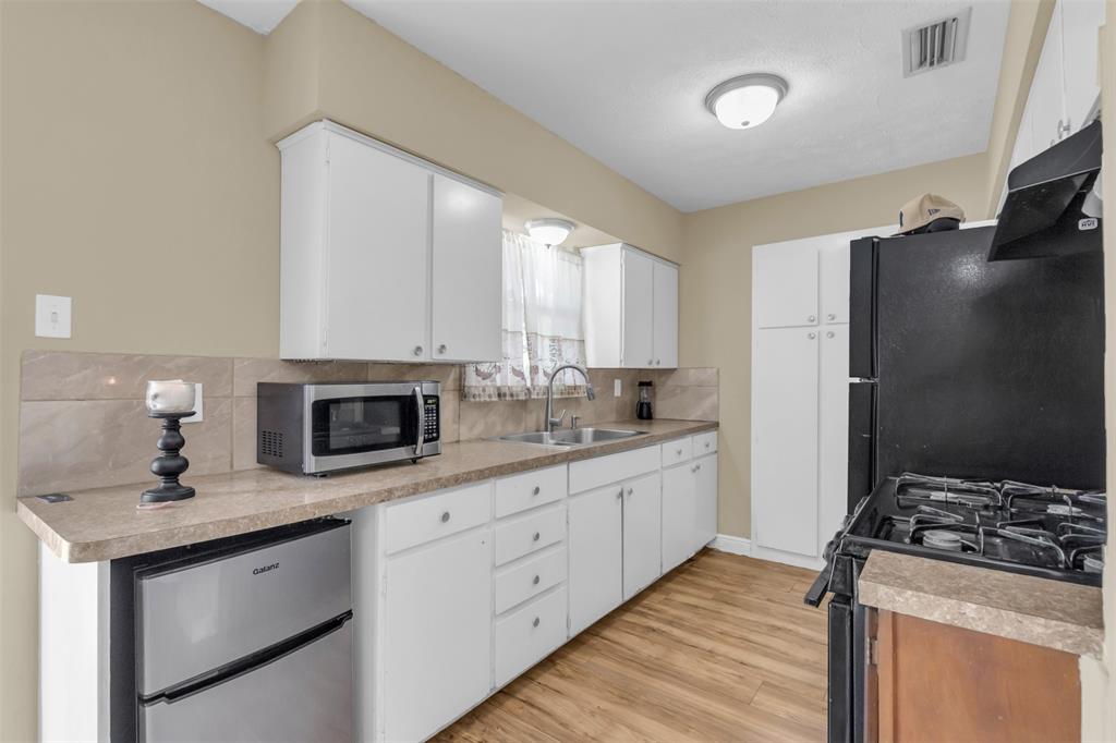 2311 Arcady Lane Lancaster, TX 75134 - Photo 10 of 22 a kitchen with stainless steel appliances granite countertop a stove a sink and a refrigerator