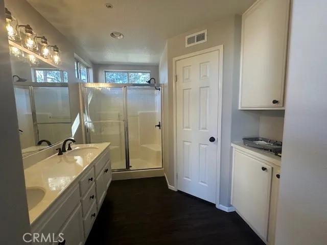 a bathroom with a double vanity sink a large mirror and a bathtub