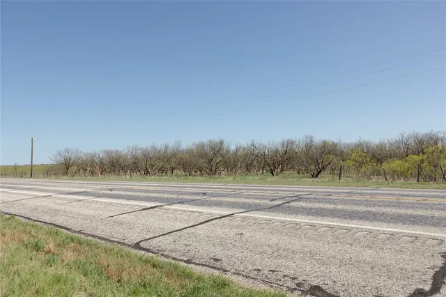 a view of a field with trees in background