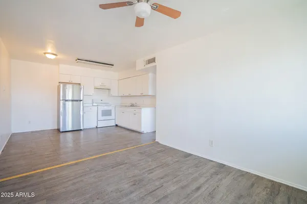 a kitchen with a refrigerator and white cabinets