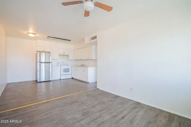 a kitchen with a refrigerator and white cabinets