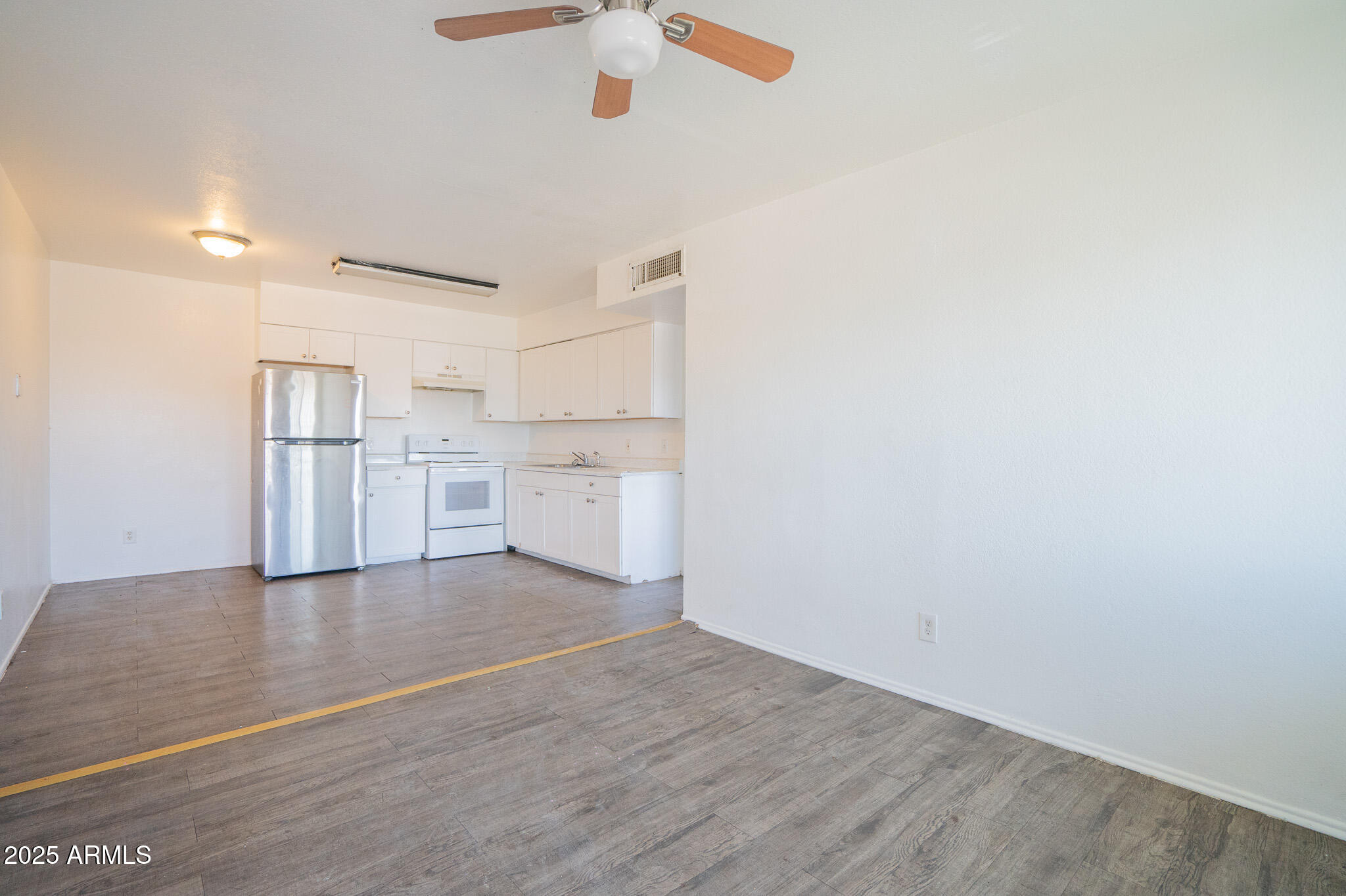 1703 West Mountain View Road, Unit 15 Phoenix, AZ 85021 - Photo 5 of 11 a view of a kitchen with a sink and dishwasher a refrigerator with wooden floor