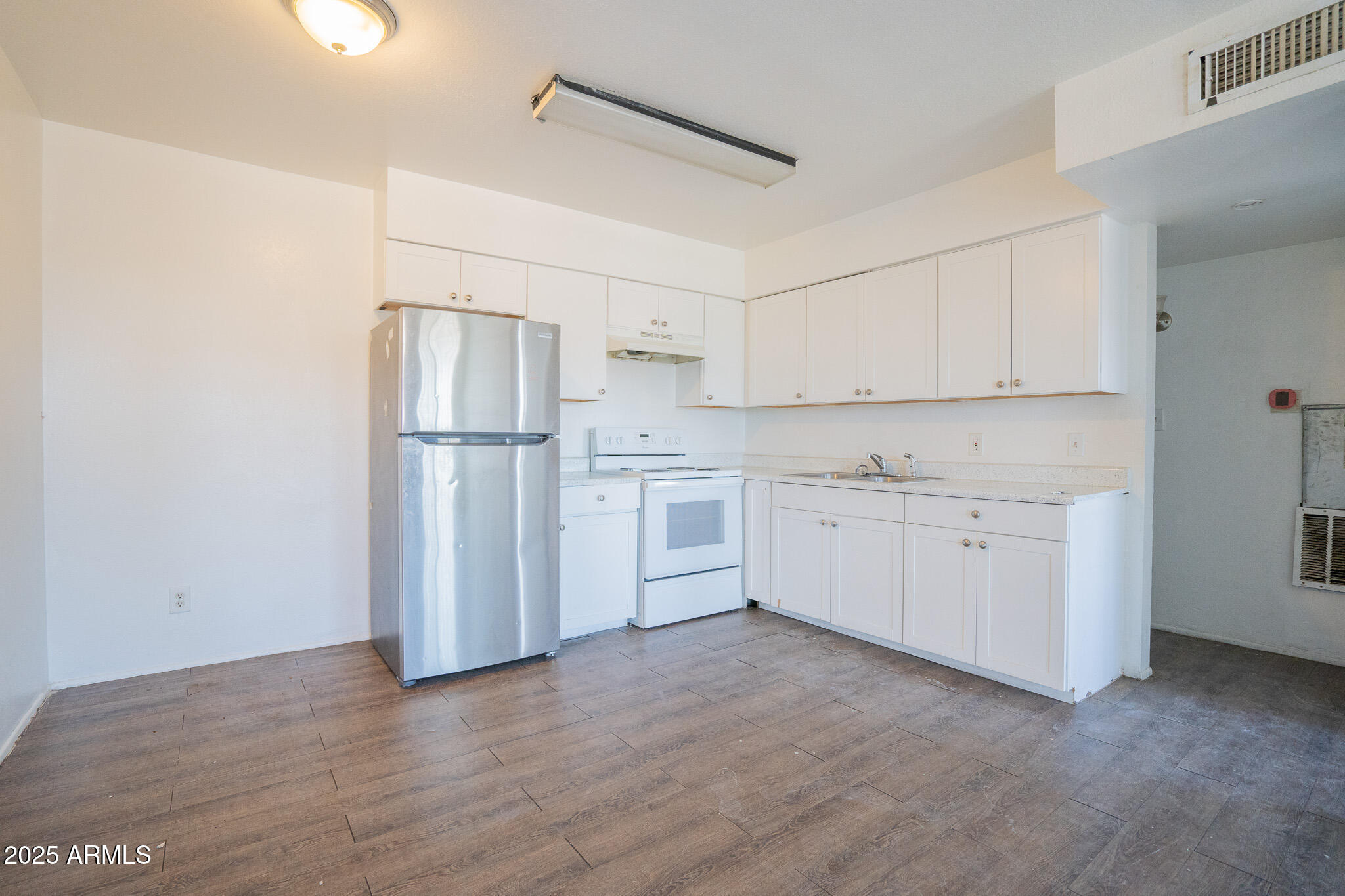 1703 West Mountain View Road, Unit 15 Phoenix, AZ 85021 - Photo 6 of 11 a kitchen with white cabinets and white appliances