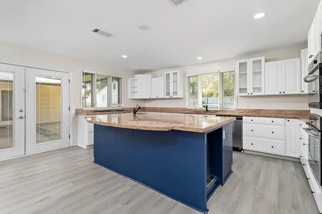 a kitchen with stainless steel appliances granite countertop a sink stove and cabinets