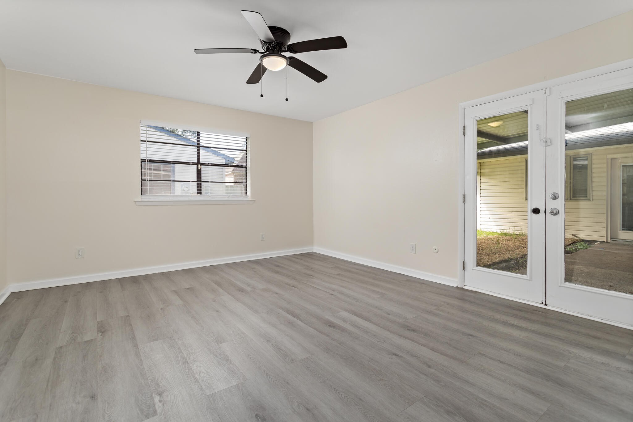 4455 Arthur Street Beaumont, TX 77706 - Photo 18 of 23 an empty room with wooden floor chandelier fan and windows