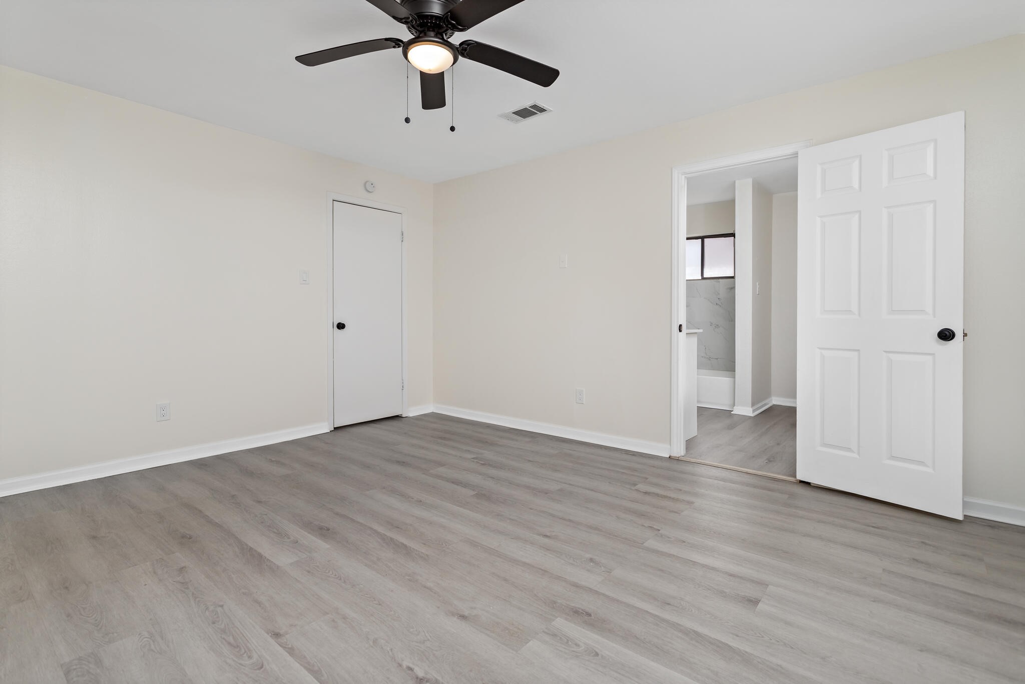 4455 Arthur Street Beaumont, TX 77706 - Photo 19 of 23 an empty room with wooden floor ceiling fan and windows