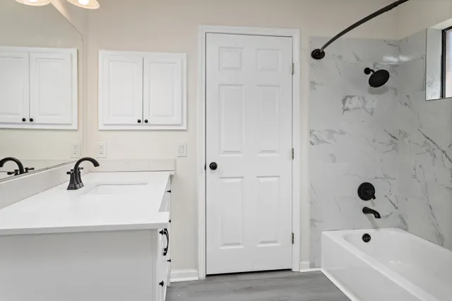 a bathroom with a tub a sink and a shower