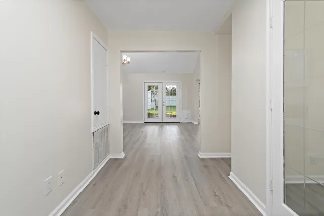 a view of a hallway with wooden floor