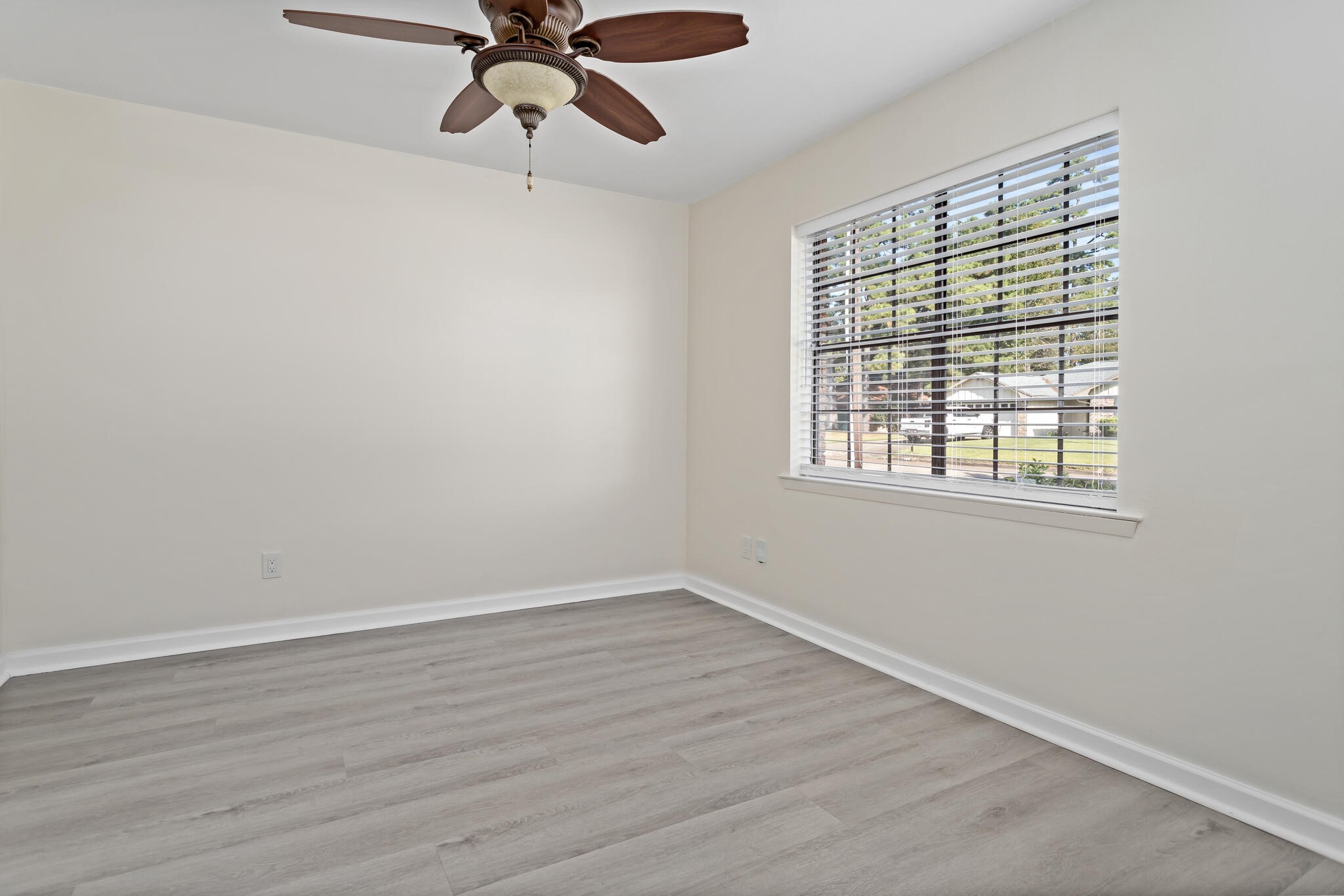 4455 Arthur Street Beaumont, TX 77706 - Photo 4 of 23 a view of an empty room with wooden floor and a window
