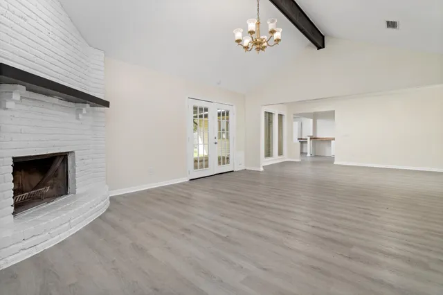 a view of empty room with a fireplace and wooden floor