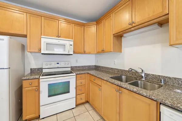 a kitchen with granite countertop cabinets stainless steel appliances a sink and a window