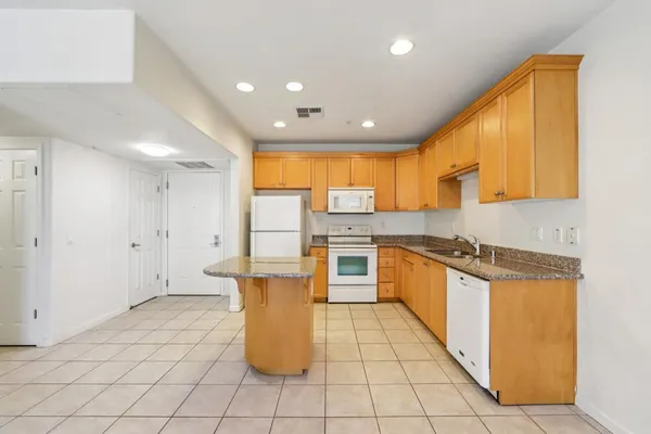 a kitchen with a sink a counter top space cabinets and stainless steel appliances