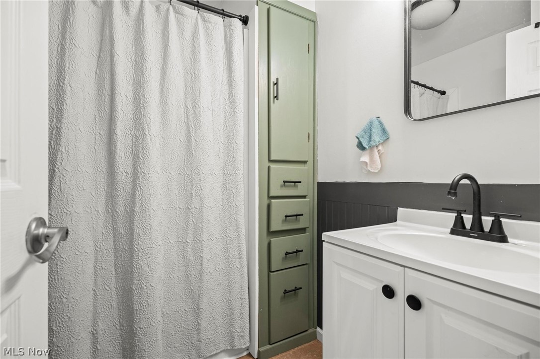 1088 Novak Road Grafton, OH 44044 - Photo 11 of 33 Full bathroom with a shower with curtain, vanity, and a wainscoted wall