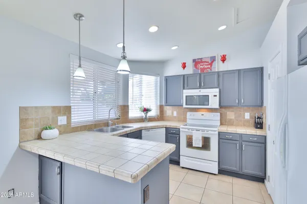 a kitchen that has a lot of cabinets in it and wooden floors