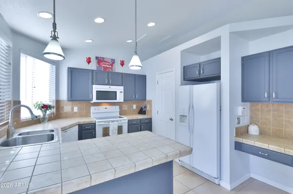 a kitchen with a refrigerator a stove and cabinets