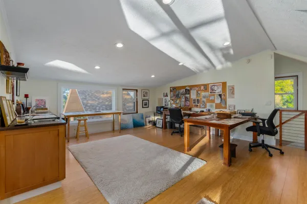 a kitchen with stainless steel appliances kitchen island granite countertop a refrigerator a stove and a wooden floors