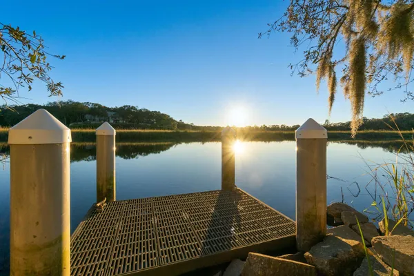 a view of a lake with couches and wooden fence