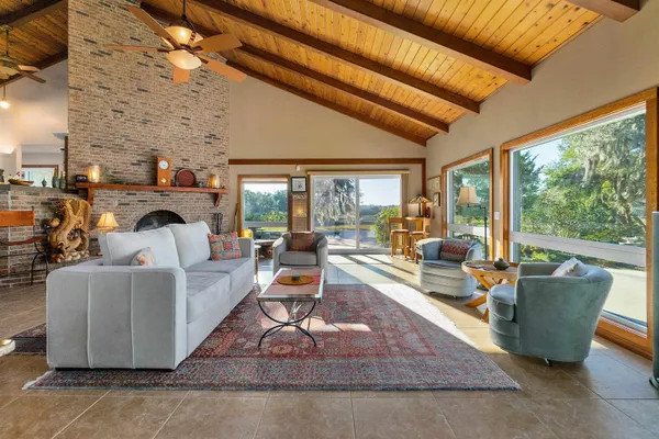 a living room with fireplace furniture and a floor to ceiling window