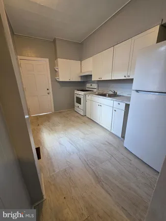 a kitchen with cabinets and wooden floor
