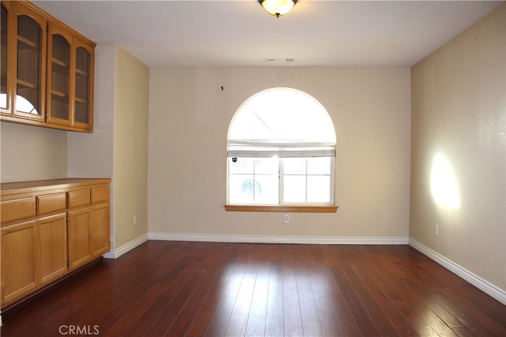 16263 Chiwi Road Apple Valley, CA 92307 - Photo 12 of 40 an empty room with wooden floor and windows