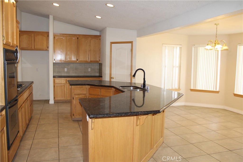 16263 Chiwi Road Apple Valley, CA 92307 - Photo 14 of 40 a kitchen with stainless steel appliances granite countertop a sink a stove and a refrigerator