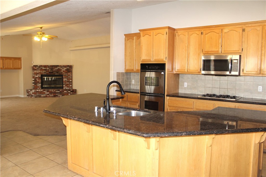 16263 Chiwi Road Apple Valley, CA 92307 - Photo 15 of 40 a kitchen with kitchen island granite countertop a sink and a counter top space