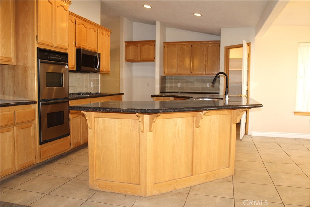 16263 Chiwi Road Apple Valley, CA 92307 - Photo 16 of 40 a kitchen with stainless steel appliances granite countertop a stove a sink and a microwave