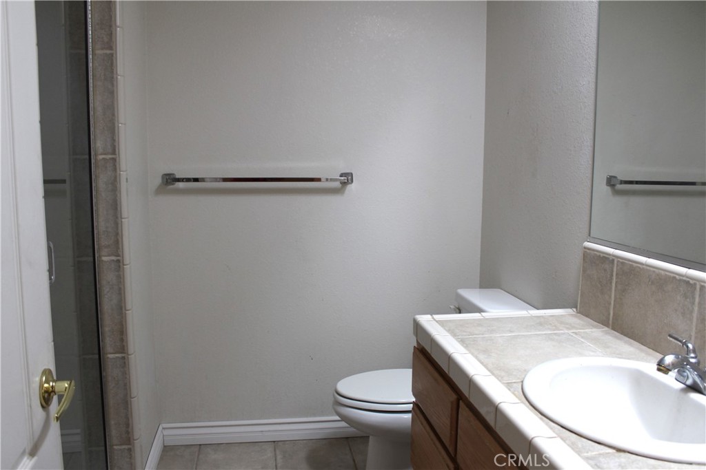 16263 Chiwi Road Apple Valley, CA 92307 - Photo 21 of 40 a bathroom with a granite countertop toilet and a sink