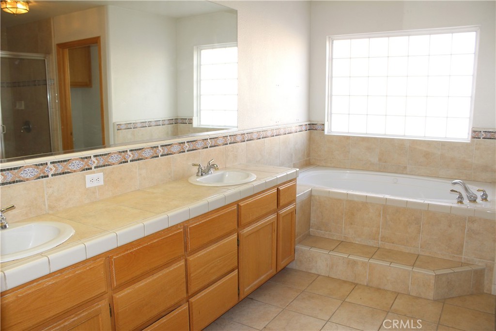 16263 Chiwi Road Apple Valley, CA 92307 - Photo 35 of 40 a bathroom with a tub sink and a mirror
