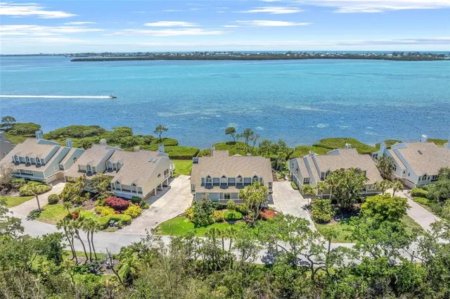 a view of a house with a yard and palm trees