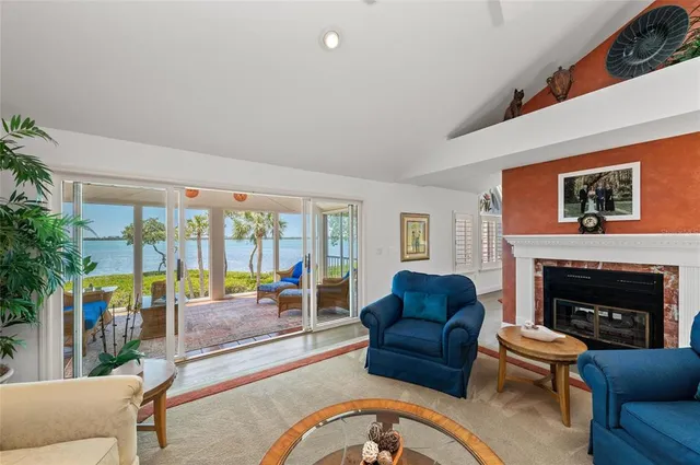 a living room with stainless steel appliances granite countertop furniture wooden floor and a rug