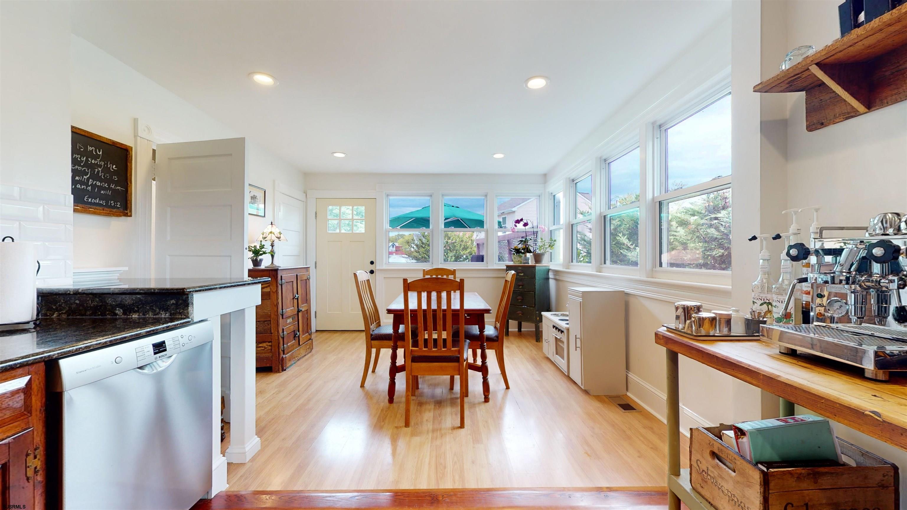 1409 Shore Road Northfield, NJ 08225 - Photo 23 of 50 a kitchen with stainless steel appliances granite countertop wooden floor a dining table and chairs