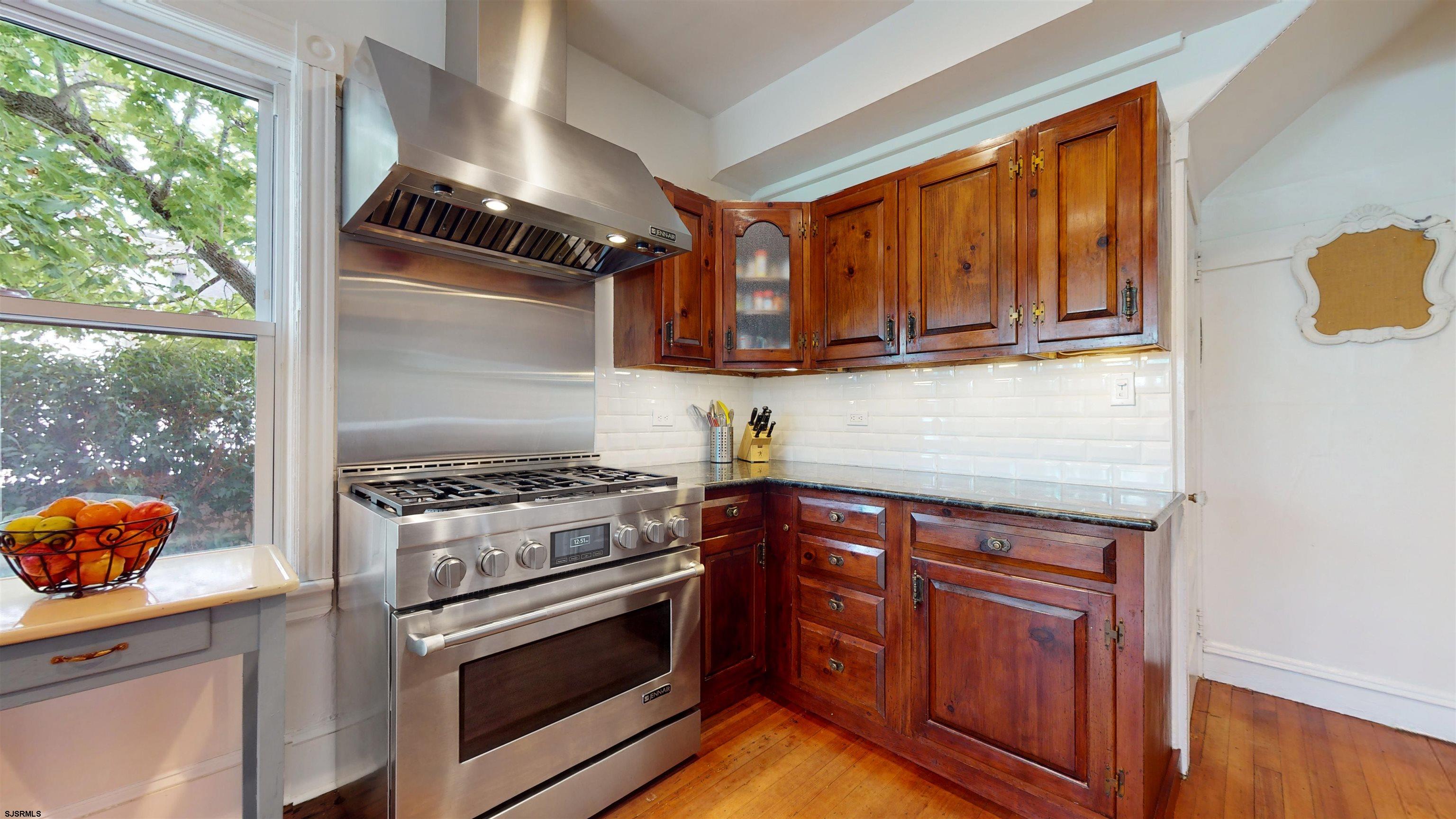 1409 Shore Road Northfield, NJ 08225 - Photo 24 of 50 a kitchen with granite countertop wooden cabinets and a stove top oven